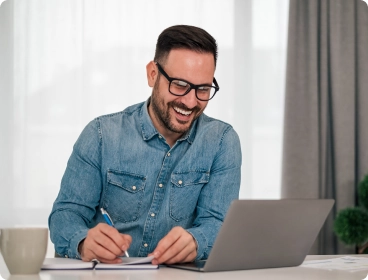 homem sorrindo em frente ao computador